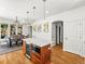 Kitchen island with a beverage cooler, pendant lights and an eat-in dining area at 4348 Umatilla St, Denver, CO 80211