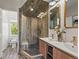 The bathroom boasts double sinks, stone floors, wood-style walls, and a glass-enclosed shower at 4348 Umatilla St, Denver, CO 80211