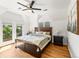 Bright main bedroom featuring hardwood floors, balcony access, and a decorative ceiling fan at 4348 Umatilla St, Denver, CO 80211