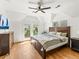 A bright main bedroom with hardwood floors, balcony access, and a decorative ceiling fan at 4348 Umatilla St, Denver, CO 80211