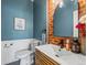 Stylish powder room featuring a modern vanity, brick accent wall, and chic decor at 4348 Umatilla St, Denver, CO 80211