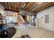 Unfinished basement with exposed ceiling, climbing wall, and a stairway leading to the upper level at 8261 Garden City Ave, Littleton, CO 80125