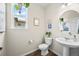 Stylish powder room features pedestal sink, and wood-look floors at 8261 Garden City Ave, Littleton, CO 80125