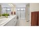 Bright bathroom features double sinks, walk-in shower, and tile floors at 8261 Garden City Ave, Littleton, CO 80125