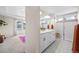 Bright bathroom features double sinks, walk-in shower, and tile floors at 8261 Garden City Ave, Littleton, CO 80125