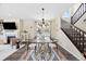 Spacious dining area with a glass table, modern rug, and open to the living room at 8261 Garden City Ave, Littleton, CO 80125