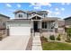 Charming two-story home featuring a manicured lawn, solar panels, and an inviting front porch at 8261 Garden City Ave, Littleton, CO 80125