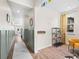 Hallway with wainscoting, light wood floors, and view to open living areas at 8261 Garden City Ave, Littleton, CO 80125