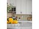 Bright kitchen featuring white cabinets, granite countertops, and stainless steel microwave at 8261 Garden City Ave, Littleton, CO 80125