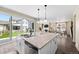 Open kitchen with white cabinets, granite countertops, and stainless steel appliances, flowing to backyard at 8261 Garden City Ave, Littleton, CO 80125