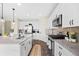 Modern kitchen with white cabinetry, granite countertops, stainless steel appliances, and wood flooring at 8261 Garden City Ave, Littleton, CO 80125