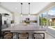 Bright, modern kitchen with a large island, pantry, and sliding glass doors to the backyard at 8261 Garden City Ave, Littleton, CO 80125