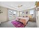 Bedroom features tray ceiling, multiple windows, and a comfortable rug at 8261 Garden City Ave, Littleton, CO 80125