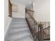 Carpeted staircase with dark wood banister leads to upper level at 8261 Garden City Ave, Littleton, CO 80125