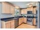 Well-lit kitchen with stainless steel appliances, light wood cabinets, and a black countertop at 13483 Achilles Dr, Lone Tree, CO 80124