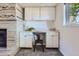 Functional office space with built-in cabinets, a desk, and a fireplace at 13483 Achilles Dr, Lone Tree, CO 80124