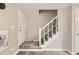Stairway with carpeted steps, white banister, and entry door to the home at 5491 E Warren Ave # 224, Denver, CO 80222