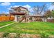 Expansive backyard featuring a deck, covered patio, and lush green lawn for outdoor enjoyment at 8871 Rutgers St, Westminster, CO 80031