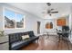 The living room includes hardwood floors, two large windows, a ceiling fan, and a futon at 8871 Rutgers St, Westminster, CO 80031