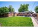 Expansive backyard featuring a well-maintained lawn, patio with dining set, and a charming brick outbuilding at 3145 W Farmdale Rd, Englewood, CO 80110
