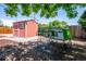 Backyard featuring a small storage shed and an enclosed chicken coop, surrounded by foliage at 3145 W Farmdale Rd, Englewood, CO 80110