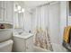 Bright bathroom with marble-look tile, modern vanity, updated fixtures, and shower with curtain at 3145 W Farmdale Rd, Englewood, CO 80110