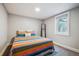 Bright bedroom with colorful bedding, a stylish mirror, and ample natural light, offering a cozy space at 3145 W Farmdale Rd, Englewood, CO 80110
