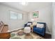 Bright bedroom boasts hardwood floors, a decorative rug, and comfy seating, enhancing the room's charm at 3145 W Farmdale Rd, Englewood, CO 80110