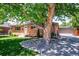 Brick home featuring a mature tree with rock landscaping and detached garage with driveway at 3145 W Farmdale Rd, Englewood, CO 80110