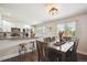 Bright, combined kitchen and dining area with white cabinets, modern appliances, breakfast bar, and dining table at 3145 W Farmdale Rd, Englewood, CO 80110