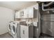 Well-organized laundry room features modern appliances, cabinets, and countertop space for convenience at 3145 W Farmdale Rd, Englewood, CO 80110