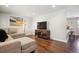 Cozy living room with hardwood floors, neutral walls, comfortable sectional couch, and entertainment center at 3145 W Farmdale Rd, Englewood, CO 80110