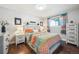 Cozy bedroom with decorative bedspread, light walls, white dresser, and window at 3145 W Farmdale Rd, Englewood, CO 80110