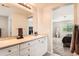 Bathroom with double vanity, white cabinets and drawers, and a large mirror, with a bedroom view at 12125 Helena St, Brighton, CO 80603