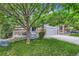 Charming home with covered porch, seating area, stone accents, manicured lawn, and mature trees at 12125 Helena St, Brighton, CO 80603
