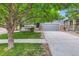 Charming home with gray siding, stone accents, mature trees, and a two car garage at 12125 Helena St, Brighton, CO 80603