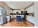 Well-lit kitchen with white cabinets, stainless steel appliances, and a dark blue kitchen island at 12125 Helena St, Brighton, CO 80603