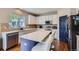 Bright kitchen with white cabinets, stainless steel appliances, and a blue kitchen island at 12125 Helena St, Brighton, CO 80603