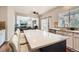 Bright kitchen with white cabinets, stainless steel appliances, a blue island, and sliding glass door at 12125 Helena St, Brighton, CO 80603