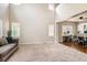 Spacious living room with large windows, plush carpeting, and hardwood floor dining area at 12125 Helena St, Brighton, CO 80603