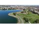 Beautiful aerial view of a community lake and path, with a playground and homes in the background at 9255 Melborne Ct, Parker, CO 80134