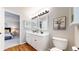 Bathroom featuring double sinks, white cabinets, and a view into the bedroom at 9255 Melborne Ct, Parker, CO 80134