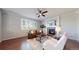Cozy living room featuring a fireplace, ceiling fan, and plantation shutters for a bright and inviting space at 9255 Melborne Ct, Parker, CO 80134