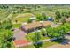 This aerial shows a charming home surrounded by lush trees, a white fence, and an expansive green yard at 9880 E 157Th Ave, Brighton, CO 80602