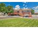 This backyard features a well-manicured lawn, a spacious deck with stairs, and a charming pergola-covered seating area at 9880 E 157Th Ave, Brighton, CO 80602