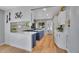 Modern kitchen with white cabinets, navy island, stainless appliances, and hardwood floors at 9880 E 157Th Ave, Brighton, CO 80602