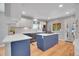 Bright kitchen featuring white cabinets, a navy island, stainless steel appliances, and hardwood floors at 9880 E 157Th Ave, Brighton, CO 80602