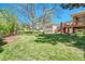 Picturesque backyard with lush green lawn, mature trees, and playset offer ample space for outdoor activities at 5255 Ridge Trl, Littleton, CO 80123