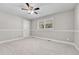 An empty bedroom with light gray walls, carpet, one window with blinds, white trim, and a ceiling fan at 5255 Ridge Trl, Littleton, CO 80123