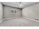 An empty bedroom with light gray walls, carpet, one window with blinds, and a ceiling fan at 5255 Ridge Trl, Littleton, CO 80123